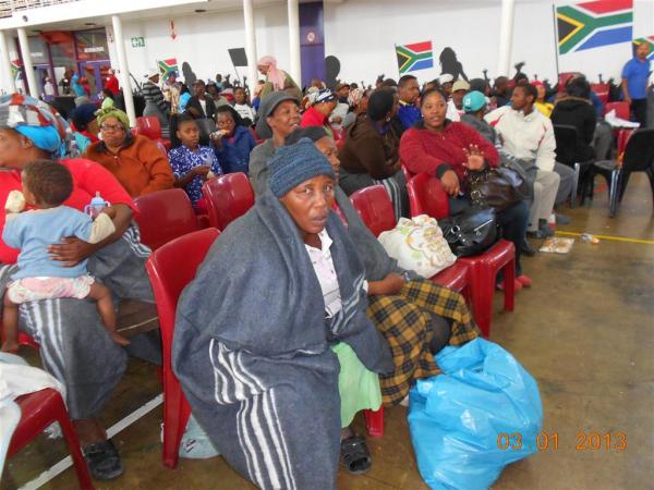 A woman huddles in a blanket in Oliver Tambo Hall. Photo by Nathan Geffen.