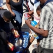 Residents in Lower Crossroads descend on a crate of bread left by a Somali shopkeeper who fled the area on Thursday. Photo by Daneel Knoetze Residents in Lower Crossroads descend on a crate of bread left by a Somali shopkeeper who fled the area on Thursday. Photo by Daneel Knoetze