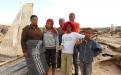 Ntombi and her family stand on their ruined house. Photo by Faizel Slamang.