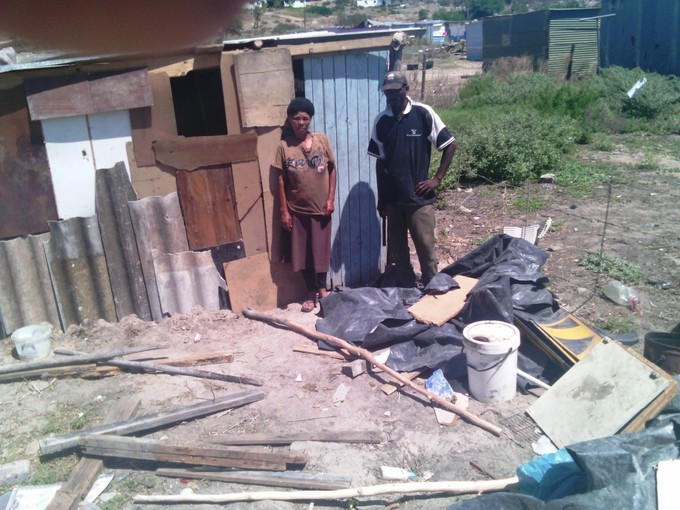 Photo of two people rebuilding their shack