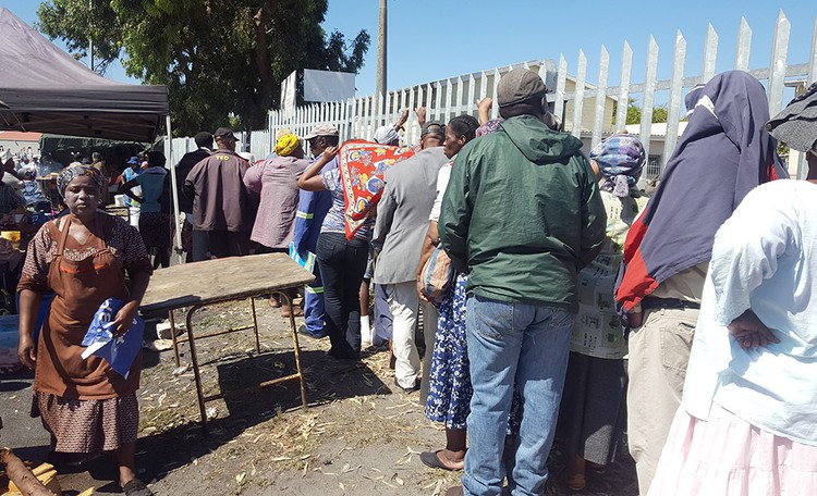 Photo of people standing in a queue for social grants