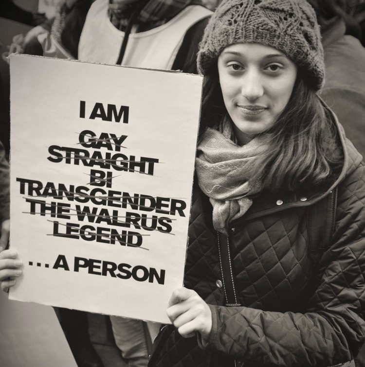 Photo of person holding poster saying I am Gay Straight Bi Transgender The Walrus Legend ... A Person
