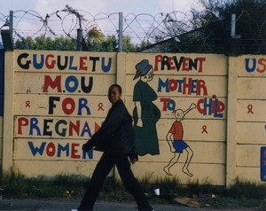 Photo of woman walking past PMTCT graffiti
