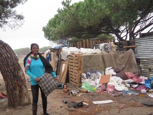 Photo of woman standing outside shack
