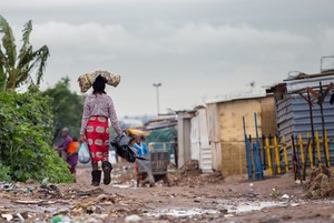 Photo of a woman walking in an informal settlement