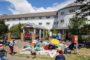 Photo of building with people's beds on the lawn