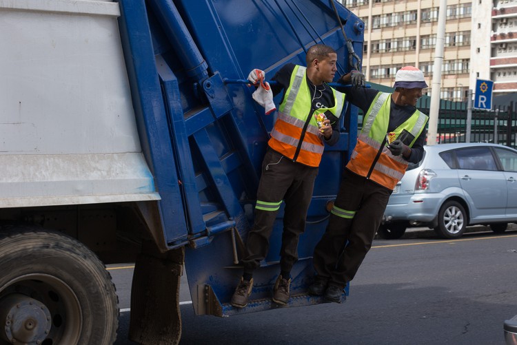 Photo of two people on garbage truck