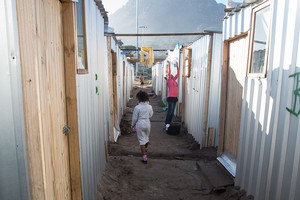Photo of shacks and a child