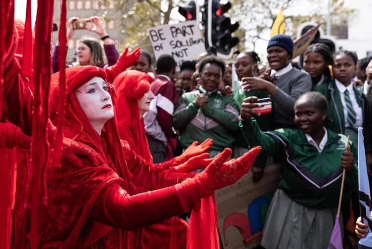 Members of the activist group Red Rebels perform during a protest for climate change in Cape Town. - Ashraf Hendricks