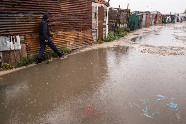 Photo of a flooded street with shacks