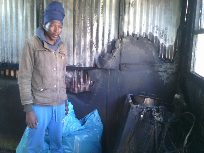 Photo of man in his brother\'s burned shack.