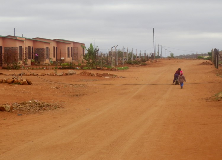 Photo of a dusty street and RDP houses