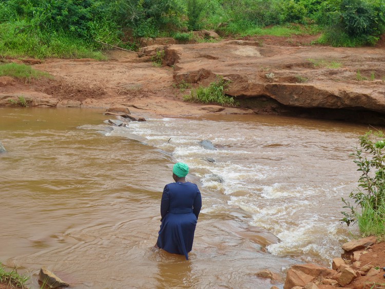 Photo of woman crossing a river