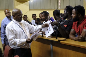 Photo of man handing out numbers in court