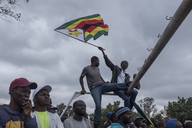 At the Zimbabwe Grounds some men climbed a soccer goal post and waved the Zimbabwean flag.