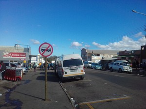 Photo of taxi in road under "no taxis" sign