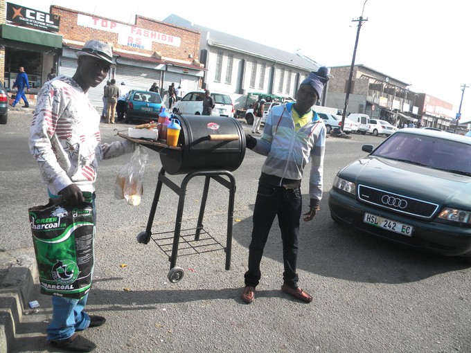 Photo of two men carrying a barbecue stand