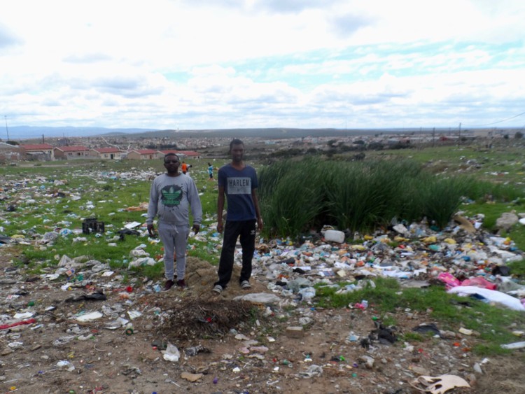 Photo of two men in a littered field