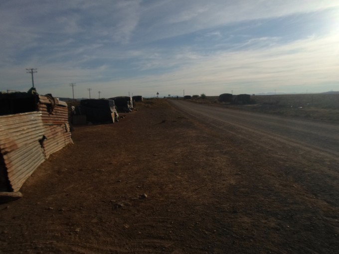 Photo of shacks along dust road