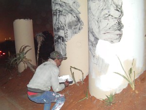Photo of man painting concrete pillar