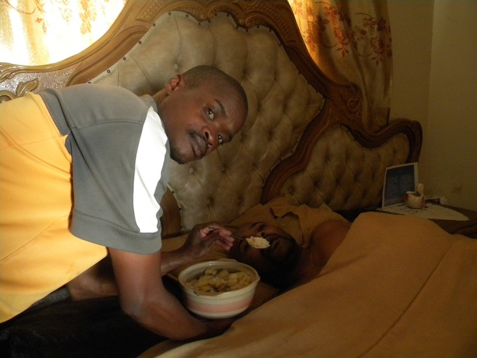 Photo of a man in bed being hand fed