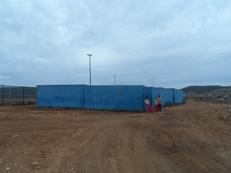 Photo of people in front of shipping containers
