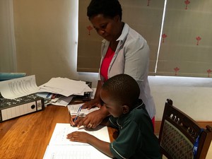 Photo of mother with child doing schoolwork