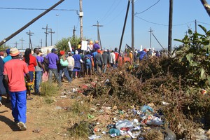Photo of people marching past rubbish