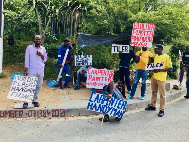 Photo of men by a roadside holding signs