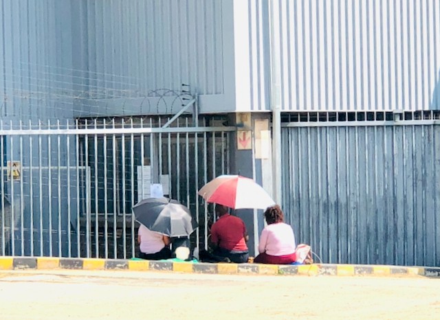 Photo of three women under an umbrella