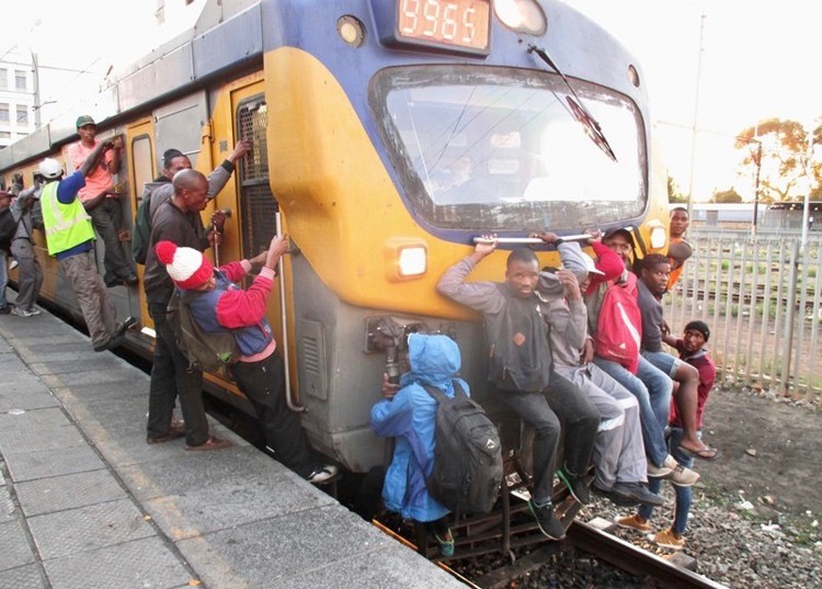Photo of people hanging on to a train