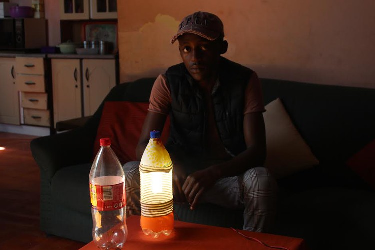 Photo of man with lamp made out of bottle