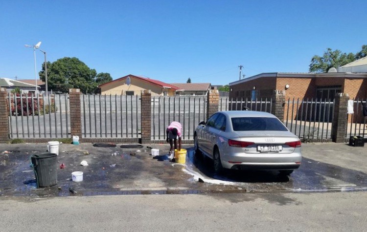 Photo of a man washing a car