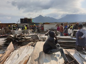 Photo of person sitting in rubble of fire