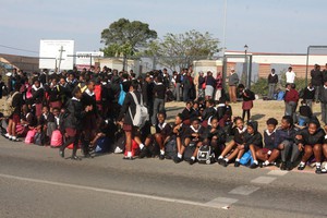 photo of leaners sitting outside the school