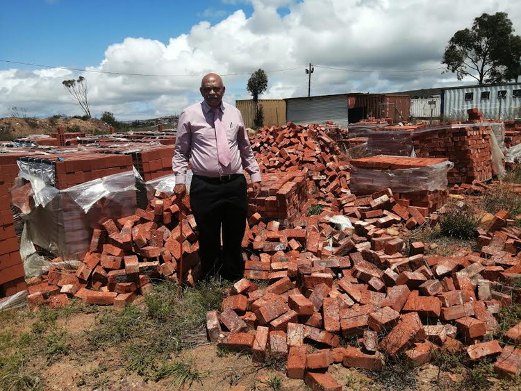 Photo of man with pile of bricks