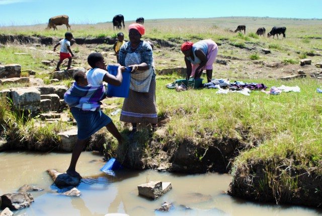 Photo of people collecting water at a river