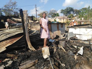 Photo of woman standing on burnt ruins
