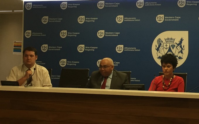 Photo of three people at a press conference