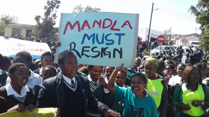 Photo of protesters with placard saying Mandla must resign