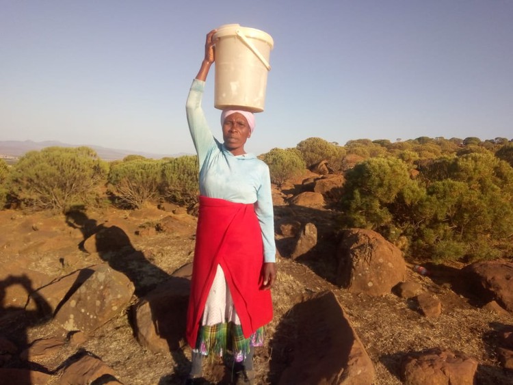 Photo of woman carrying water on her head