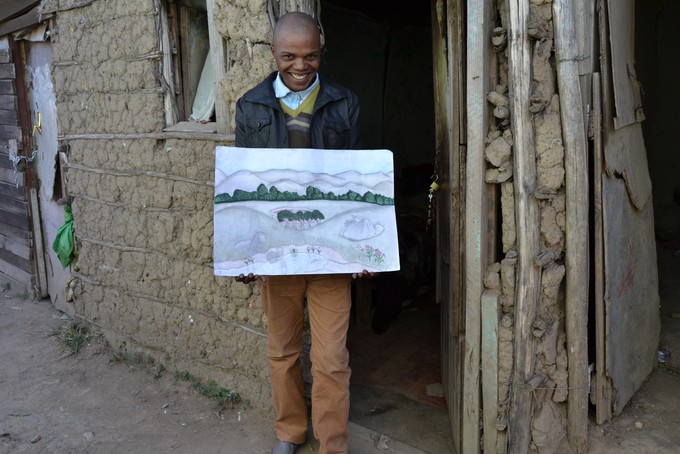 Photo of man outside his mud room, with one of his paintings