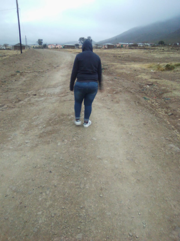 Photo of woman walking along road