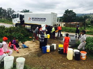 Photo of truck and people collecting water from it