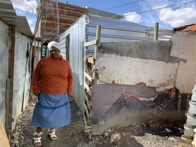 Photo of woman in front of shack