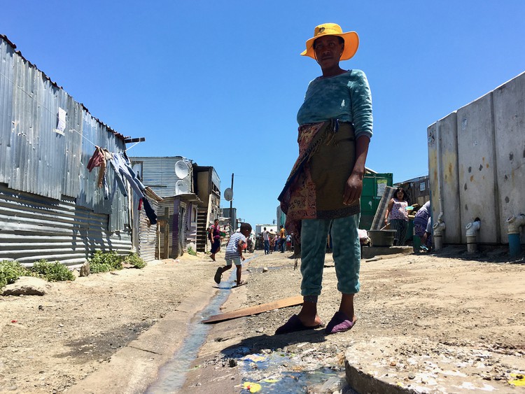 Photo of shacks and a polluted street
