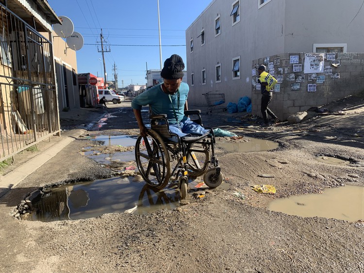 Baithuti Shasha struggles to get around Dunoon in his wheelchair because most of the roads are badly potholed and flooded with sewage. - Peter Luhanga