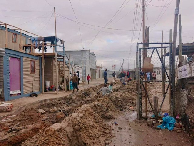Photo of long trenches on an informal settlement