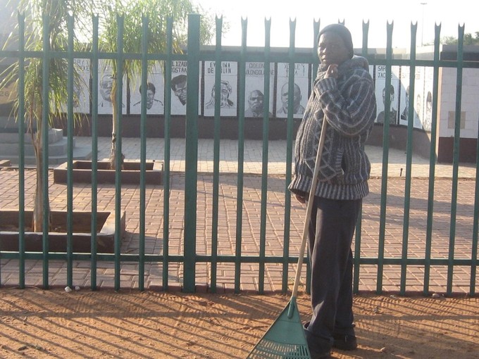 Photo of William Sifumba in front of monument to \"Upington 26\".