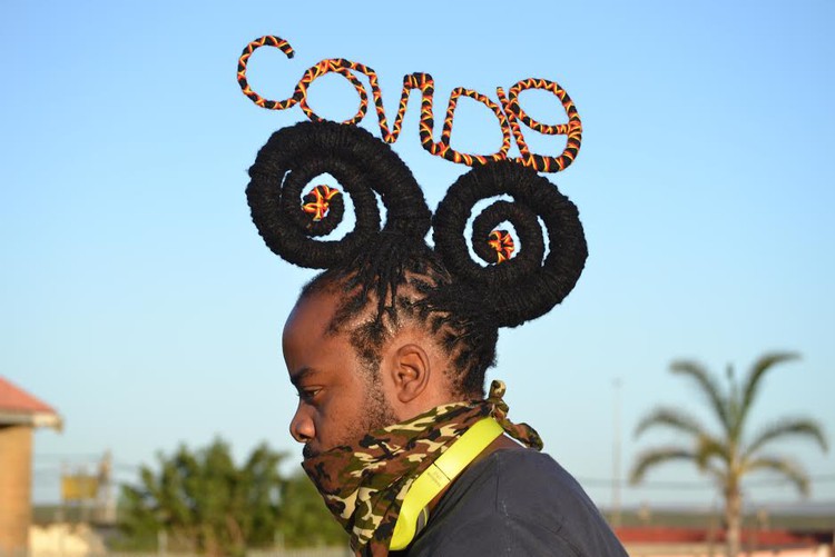 Photo of man with word in his dreadlocks